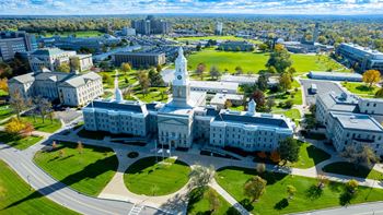 Arial view of building with a clock tower and green lawns